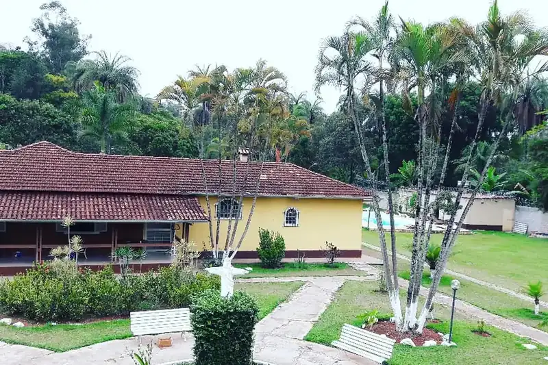 Jardim com caminhos e bancos em frente à sede